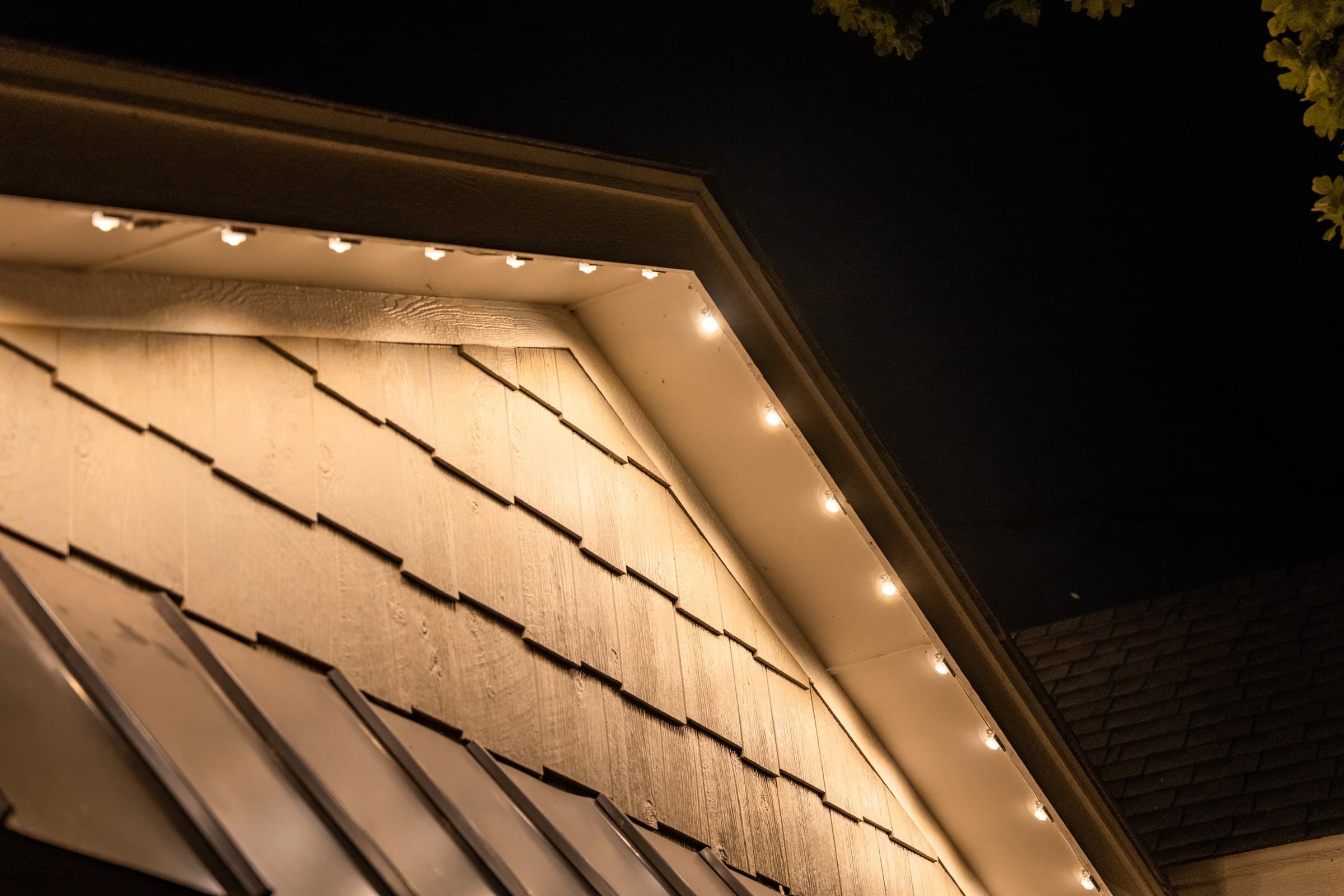 Close view of the JascoPro pucks surface-mounted under the eave, the cord run tight to the fascia