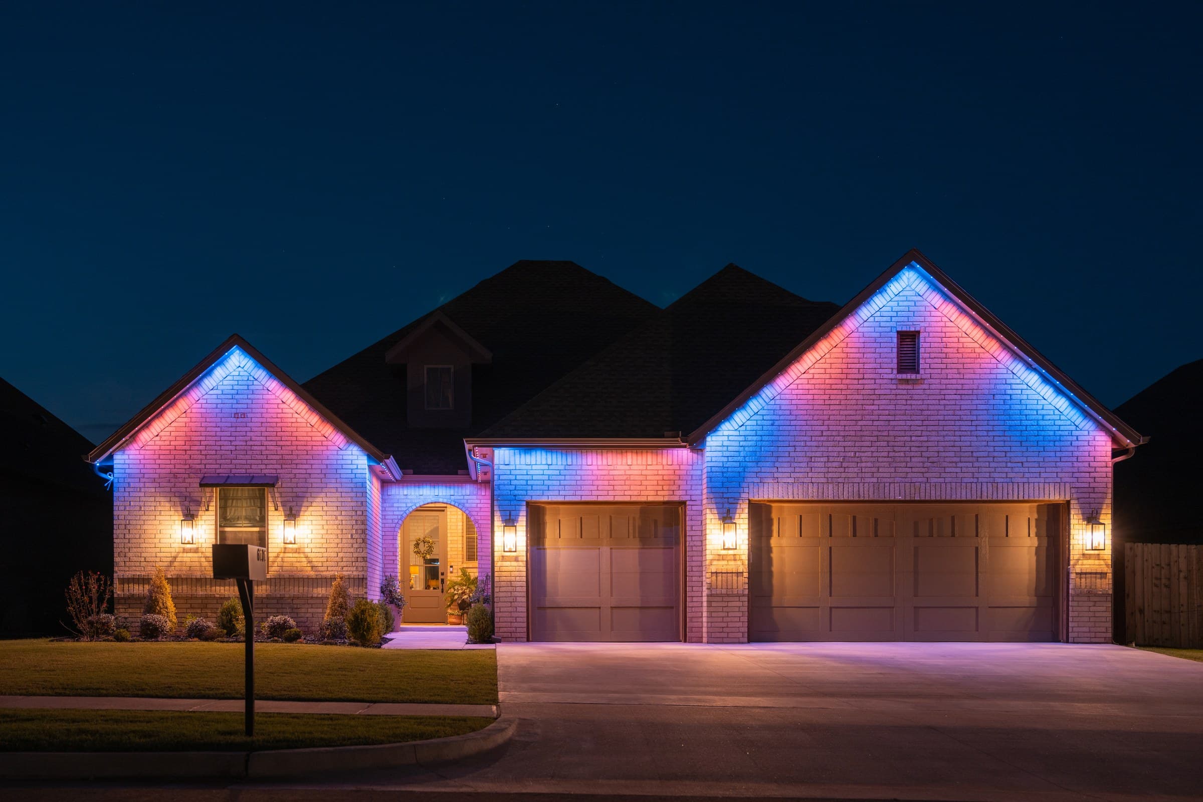 A home running a multi-color scene, with pink, blue and purple alternating along the roofline