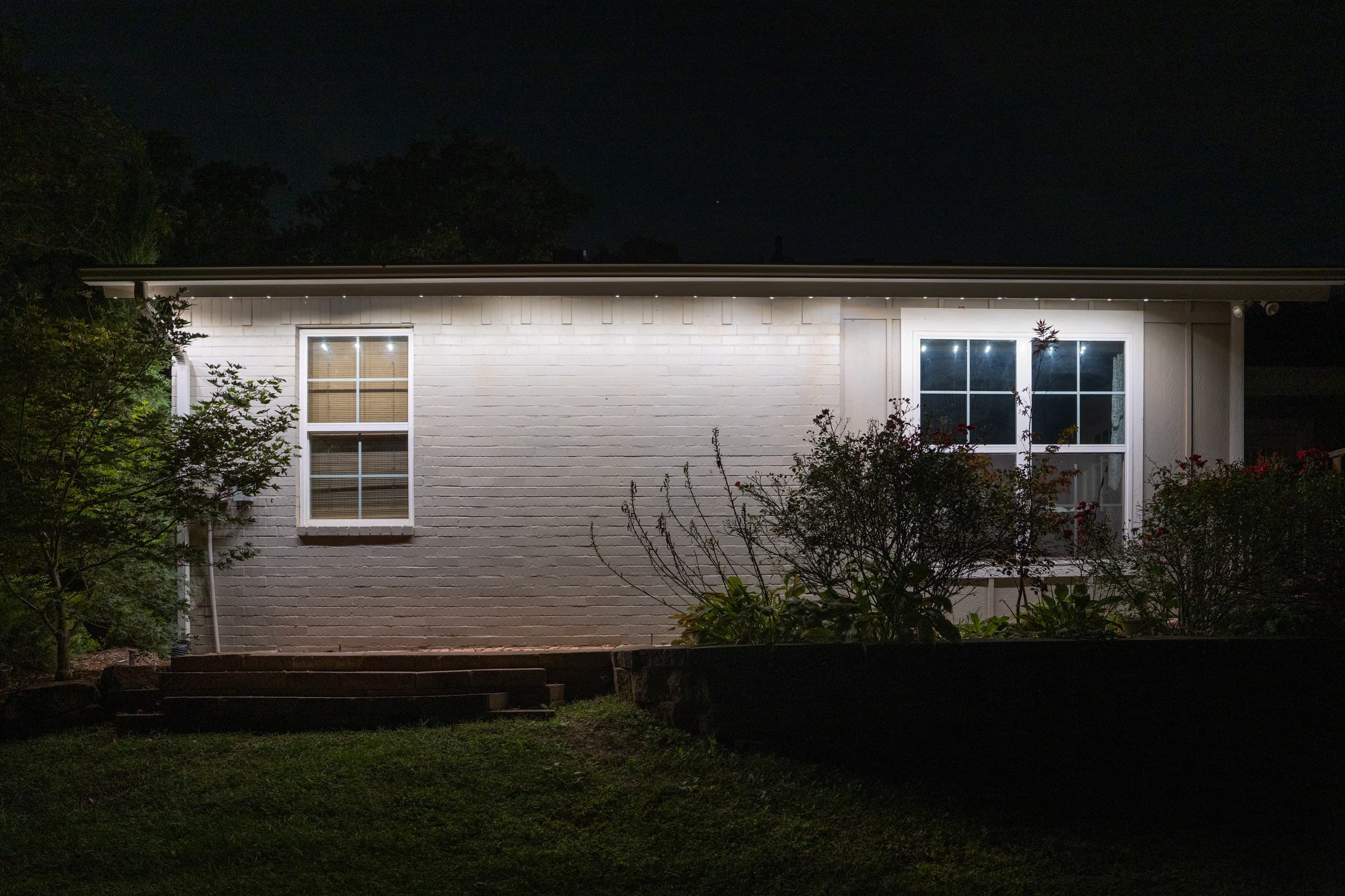 Close range view of the angled Pro Clips washing warm white light down a white brick wall
